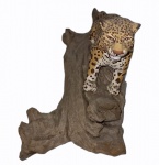 "Tigre", Goiás, peça em madeira policromada, tigre sobre tronco, medindo 14 x 11 x 26 cm.