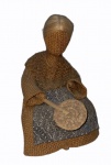 "Figura feminina com leque sentada em um banquinho de madeira", peça em tecido, estopa, madeira e palha, medindo 11 cm de altura e 3 cm de diâmetro da base.