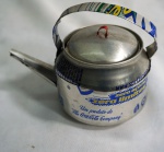 Pequena chaleira confeccionada em lata de refrigerante, medindo 9 cm de altura.