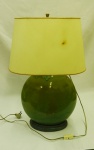 Abajur para duas lâmpadas em porcelana verde no formato ovalado com cúpula branca, sobre base de madeira ( cúpula com machas do tempo). Medidas 61 x 32 x 18 cm.