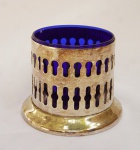 Açucareiro sem tampa em metal vazado com recipiente em vidro azul( vidro com borda lascada). Medidas 8,5 x 10 cm.