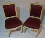 Par de cadeiras em madeira patinada, assento e encosto forrados em tecido na cor vinho, biqueiras dos pés policromadas, medindo 102x50x52cm.