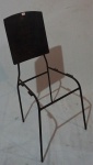 Cadeira com estrutura tubular pintada de preto, encosto em madeira, sem assento, medindo 88 x 35 x 33 cm.