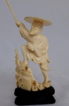 Escultura, em marfim oriental, representando pescador, sobre base de madeira entalhada, com altura de 10 cm. RETIRADA EM COPACABANA COM AGENDAMENTO.