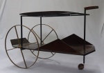 JORGE ZALSUPIN (1922/2020). Carrinho de chá em jacarandá, 2 estágios, com rodas de latão, apoiado sobre estrutura de ferro maciço, medindo 71x115x44cm.