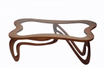 GIUSEPPE SCAPINELLI (1891-1982)   - mesa de centro em madeira nobre de peroba do campo modelo ameba em elementos roliços apoiada sob pés com tampo em vidro liso de 4 mm.