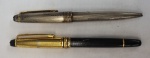Duas canetas MONTBLANC, esferográficas, antigas , sendo uma em metal prateado e outra com a tampa em metal dourado e corpo preto, medindo 14 cm. No estado.