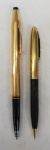 Dois lotes sendo,  uma lapiseira SHEAFER com tampa dourada , corpo preto, ponta dourada (13 cm, no estado) e uma caneta esferográfica CROSS em metal dourado(13,5 cm).