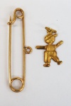 Lote composto de alfinete e pingente representando menino, em ouro amarelo, peso total 1.40 g. HORACIO ARREMATOU POR 280,00