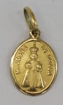 Medalha em ouro amarelo, contrastado 18k, representando Menino Jesus de Praga, peso 0.59 g, medida aproximada 15mm.