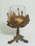 Castiçal em bronze  decorado com folhagem e recipiente em vidro. Medida: 13cm de altura.