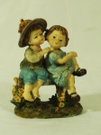 Grupo escultórico em resina, representando  casal de crianças brincando.  Med. 13 x 10 cm