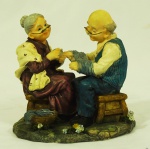 Grupo escultórico em resina, representando casal de idosos. Med. 12 x 13 cm