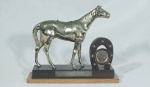 Troféu - Prêmio Brasiliana/79, (16 de setembro de 1979) Jóquei Clube Brasileiro,   escultura representando cavalo em metal dourado sobre base de madeira, med. 22cm de alt x25 cm de lar x  8 cm de prof.