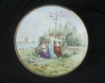 Medalhão de porcelana francesa de limoges, com pintura a mão, representando "ninfas no jardim". Bar com 31cm de diâmetro. Marcas da manufatura. Assinatura no CID.