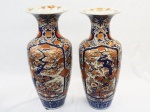 Par de imponentes vasos em porcelana japonesa Imari, ricamente decorado com flores e frutos em tons de azul cobalto, rouge de fer e ouro, medindo 77cm de altura cada. Acompanham peanha em madeira medindo 17cm de altura e 32cm de diâmetro.