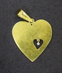 Pingente em formato de coração, medindo aprox. 4 cm, em ouro amarelo e pequeno brilhante central. Peso total 5.42 g