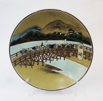 Prato de porcelana chinesa decorado com paisagem , ponte e figuras  em policromia e relevo. Diâm. 24 cm.