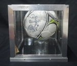 Bola Oficial da Penalty, assinada pelo Rei Pelé, em 2014 na inauguração de energia cinética da Shell. Armazenada em cubo de vidro com hastes em alumínio. Med da caixa 27,5 cm