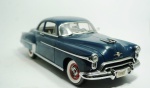 Authentics - Oldmobile, 1950, escala 1/18, azul marinho, feito de metal, medindo 28 x 10 cm. contém partes móveis.